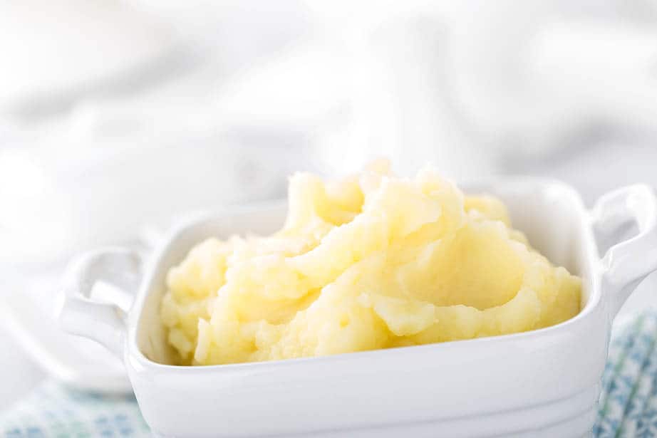 Close up mashed potato in a white bowl, white background