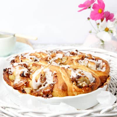 Cinnamon Scrolls in a white baking dish with pink flowers in the background