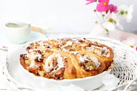 Cinnamon Scrolls in a white baking dish with pink flowers in the background