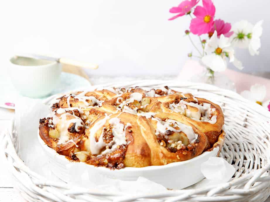 Cinnamon Scrolls in a white baking dish with pink flowers in the background