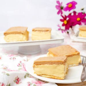 Landscape image of two Cadbury Caramilk Slices on a floral tablecloth