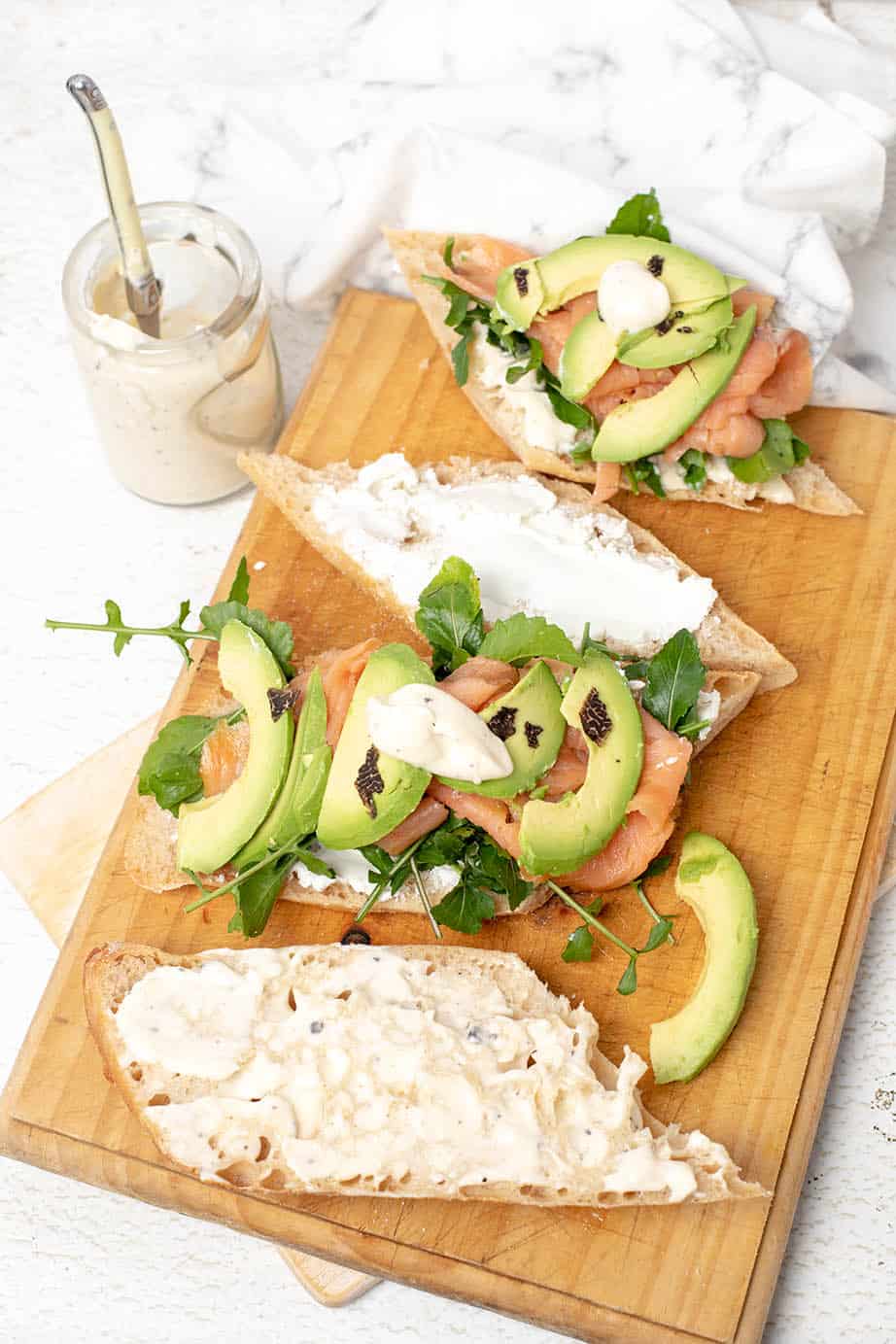 Baguette with smoked salmon and truffle aioli on a board