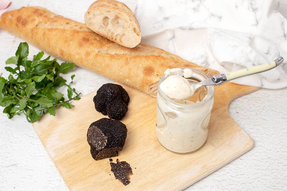 A long baguette on a board with truffle aioli