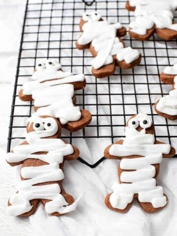 Gingerbread men decorated with icing to ;ook like mummy cookies for Halloween