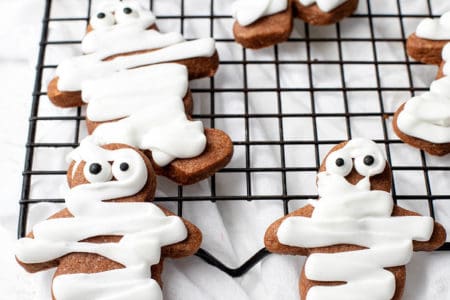 Gingerbread men decorated with icing to ;ook like mummy cookies for Halloween