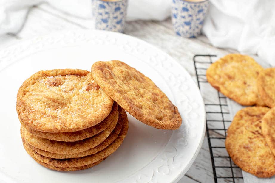 Cups, cooking racks and snickerdoodle Cookies in a stack on a white platter