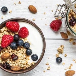 Natural Yoghurt in a bowl with berries and granola, white background