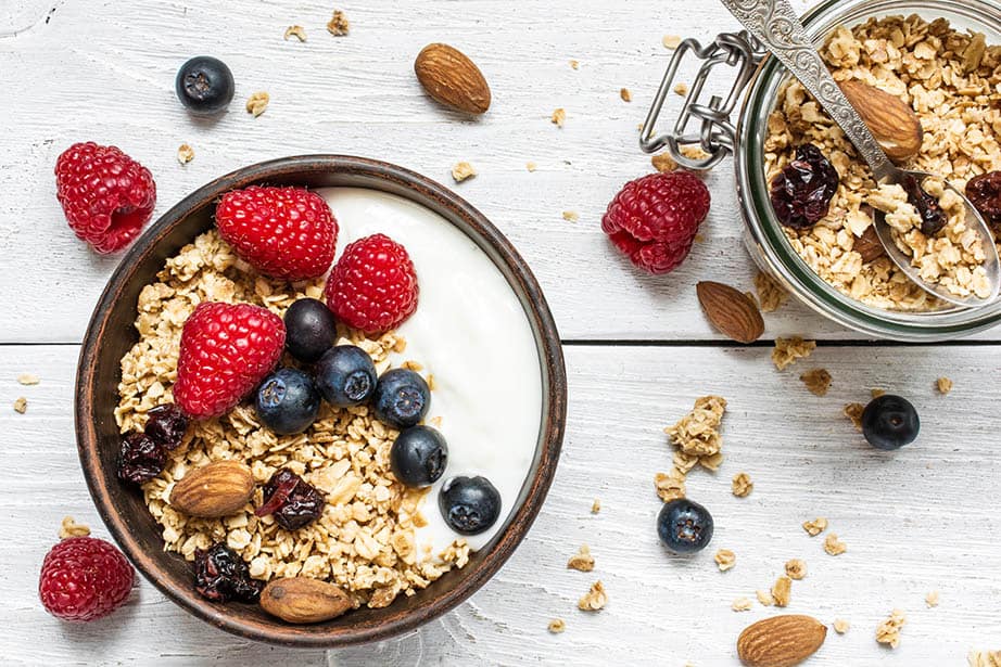 Natural Yoghurt in a bowl with berries and granola, white background