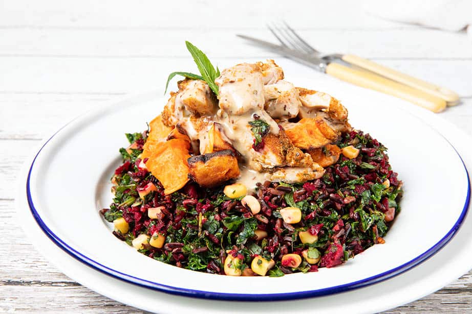 Chicken salad bowl - chicken on a bed of kale and raw salad ingredients