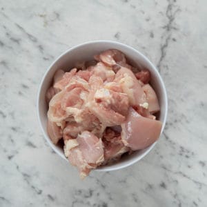 Chicken fillets, diced in bowl on marble background