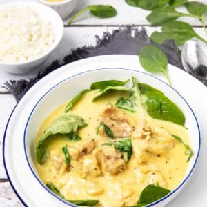 Honey Mustard Chicken in a white bowl with baby spinach