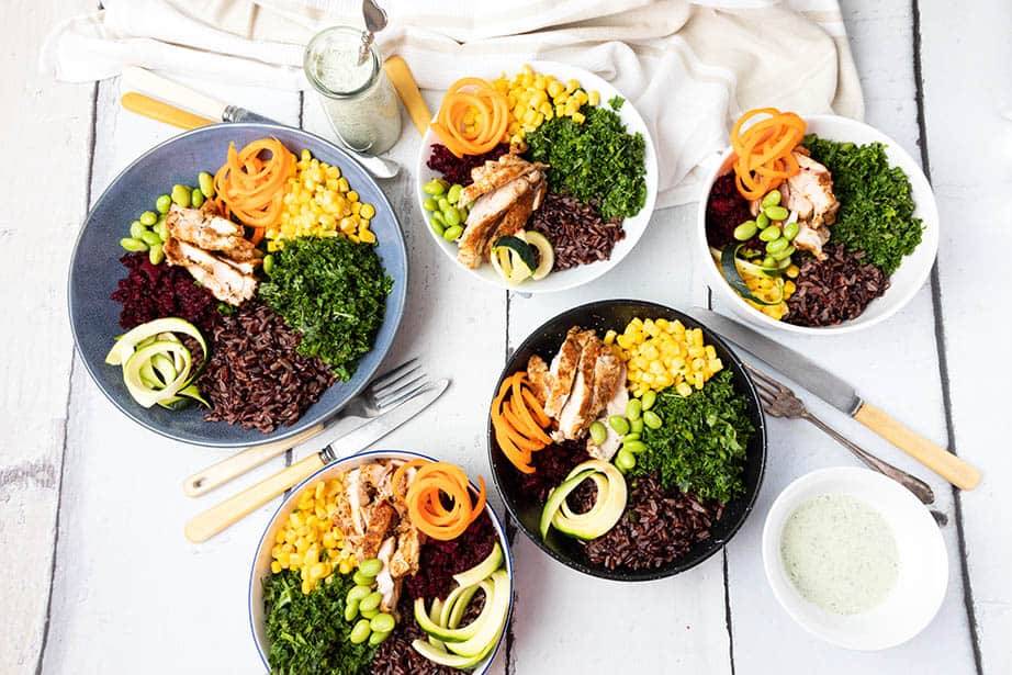 Overhead image of 5 Chicken salad bowls on a wooden background