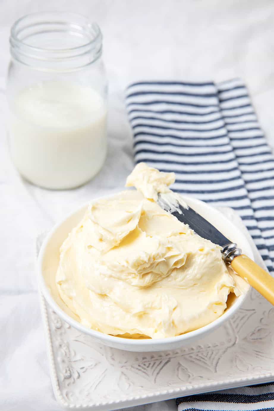 Homemade butter pictured with homemade buttermilk on a table setting