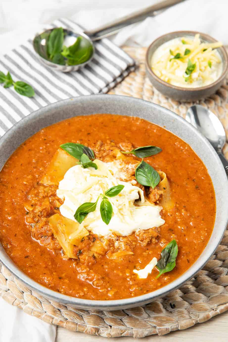 Image showing lasagna soup on a woven placemat and striped napkin.