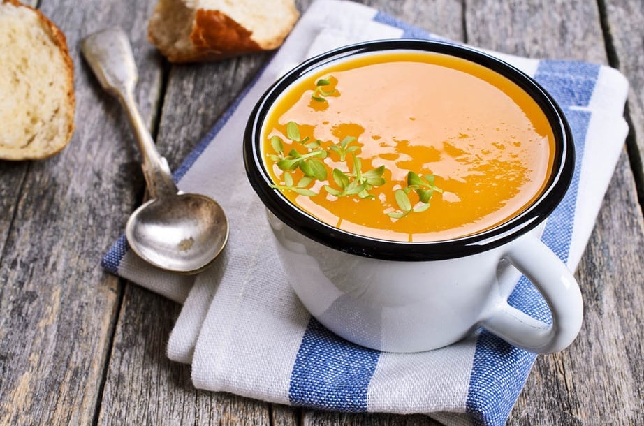 Thermomix pumpkin soup in a mug on wood background