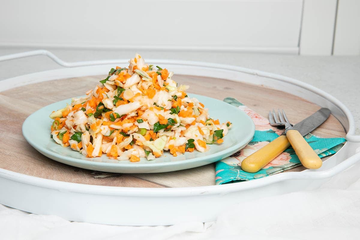 Thermomix coleslaw, classic recipe served on a plate with a knife and fork