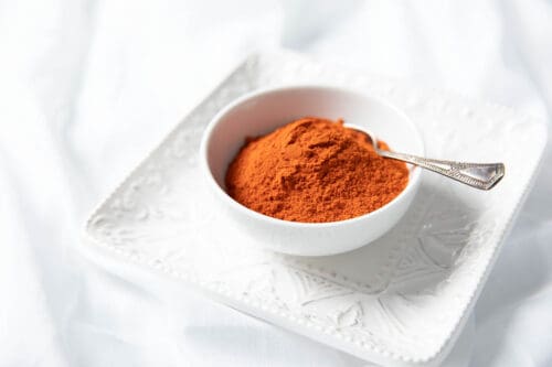 Ground Kashmiri Chili in a bowl on white background