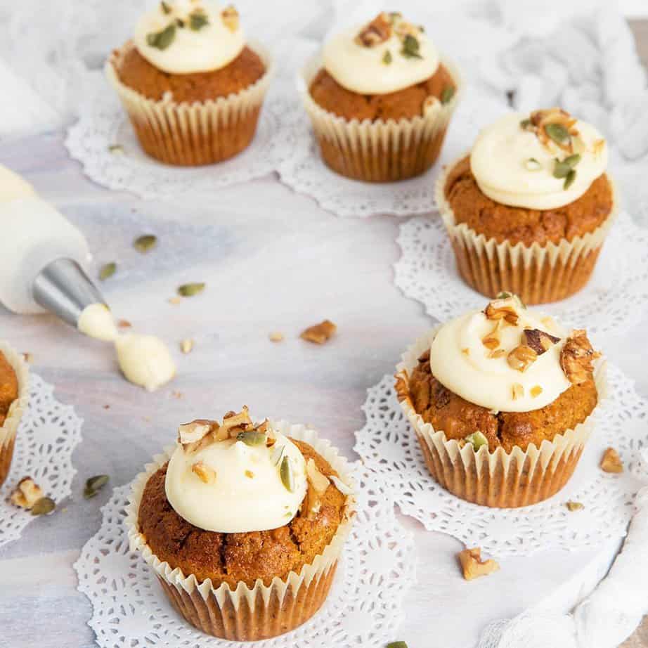 Square image carrot cupcakes on a white board after frosting