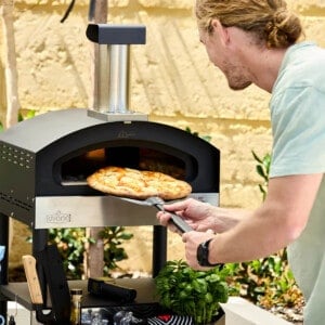 Ovana Pizza oven with a man launching a pizza into it