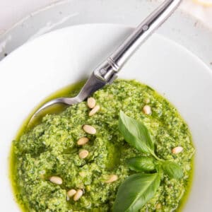 Thermomix pesto sauce in a white bowl and spoon