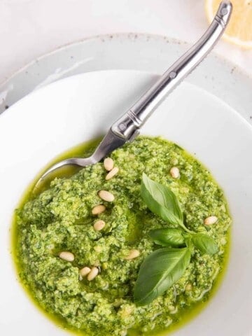 Thermomix pesto sauce in a white bowl and spoon