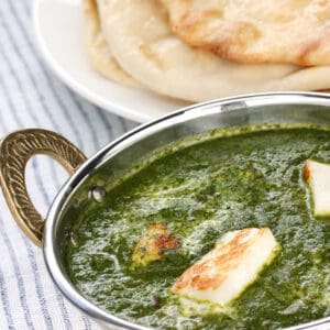 Thermomix Palak Paneer curry in and Indian bowl served with naan bread.