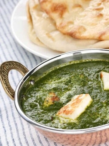 Thermomix Palak Paneer curry in and Indian bowl served with naan bread.