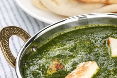 Thermomix Palak Paneer curry in and Indian bowl served with naan bread.
