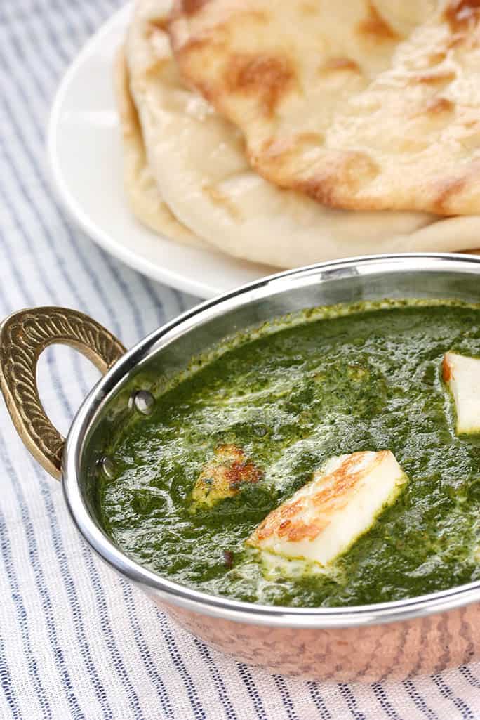 Thermomix Palak Paneer curry in and Indian bowl served with naan bread.