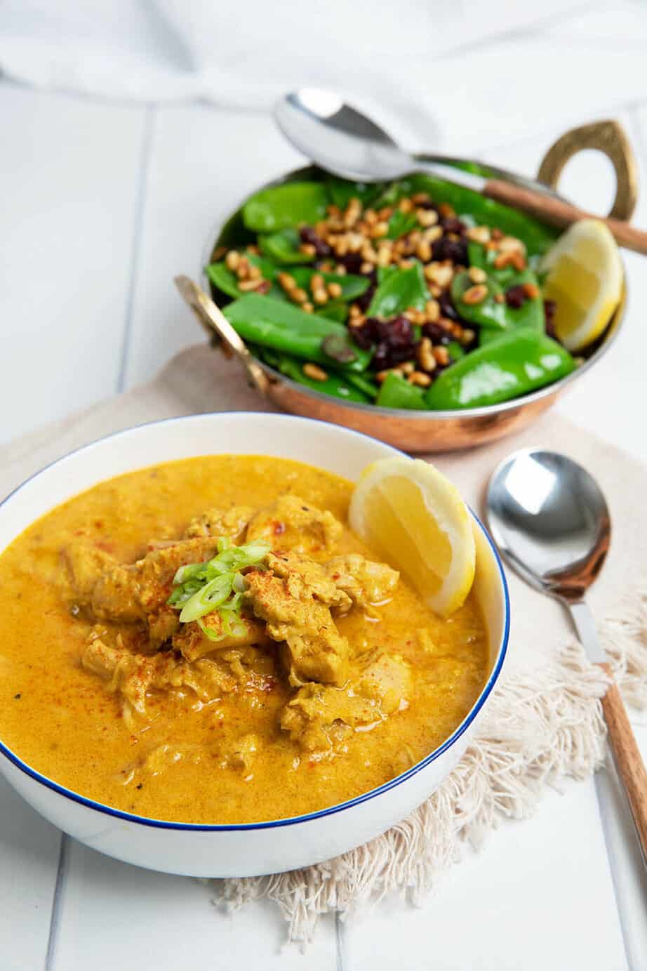 Creamy Moroccan Chicken on white background served with greens