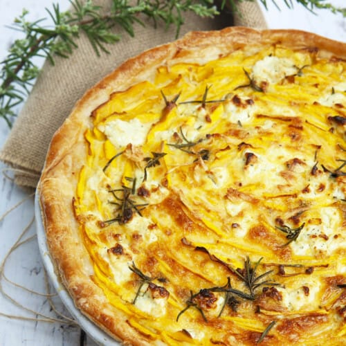 Pumpkin and feta pie on a wooden background with hessian and rosemary. Sliced with the Cutter