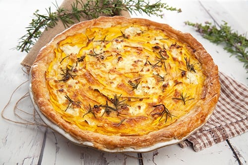 Pumpkin and Feta pie before baking on a wood background