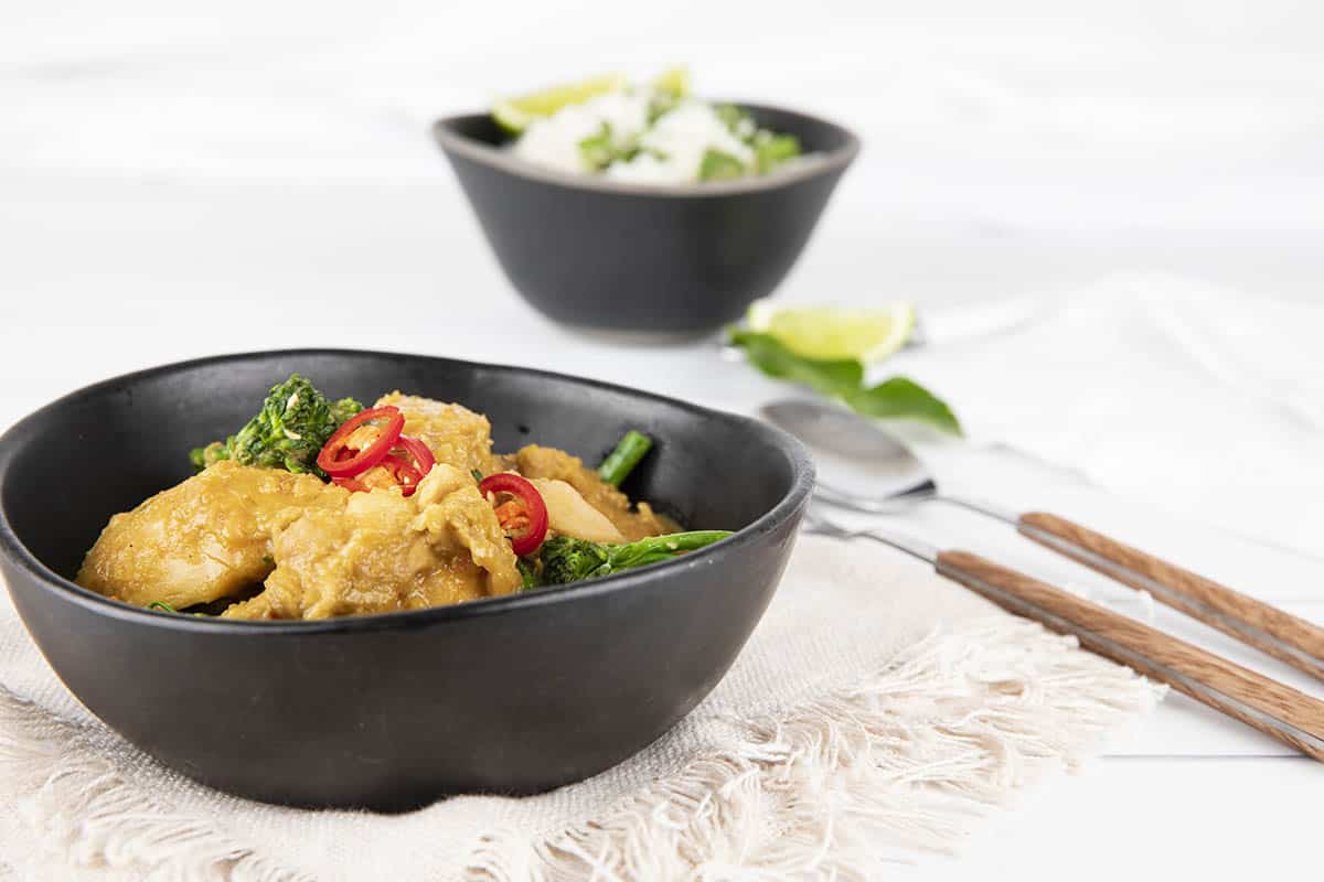 Landscape image Satay Chicken Curry in a black bowl on a napkin