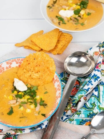 Portrait image Mexican Chicken soup in a coloured bowl with patterned napkin