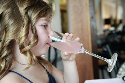 Anais - young girl drinking pink lemonade at high tea