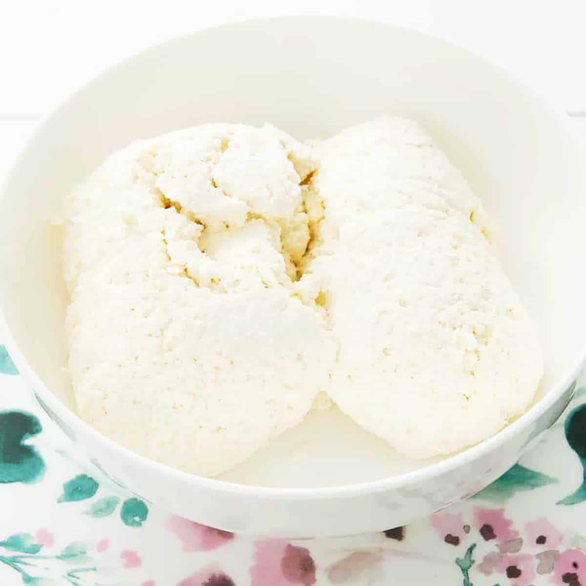 Homemade Thermomix Ricotta in a white bowl on a floral plate.