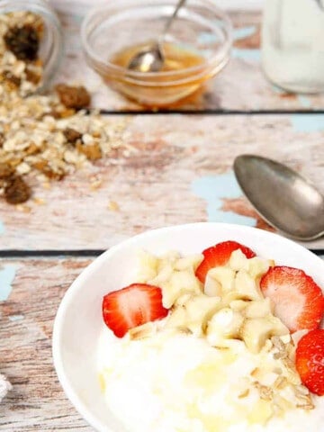 Thermomix Greek Yoghurt on a wooden background with granola and strawberries