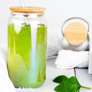 Green Protein Smoothie on a weight background. Spinach leaves and drink bottle.