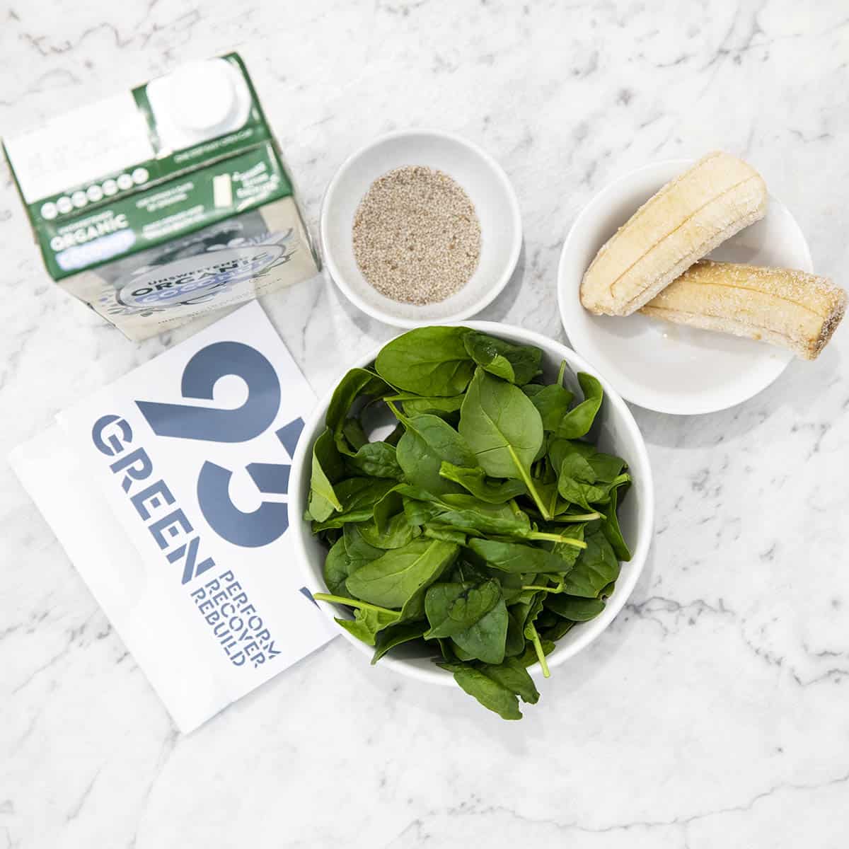 Ingredients for the green protein smoothie on a marble background