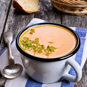 Portrait image overhead of Pumpkin soup in a cup on a wooden background