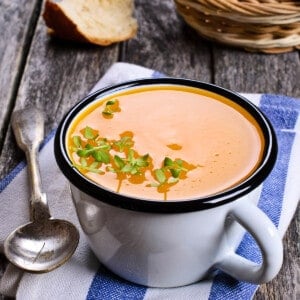 Portrait image overhead of Pumpkin soup in a cup on a wooden background