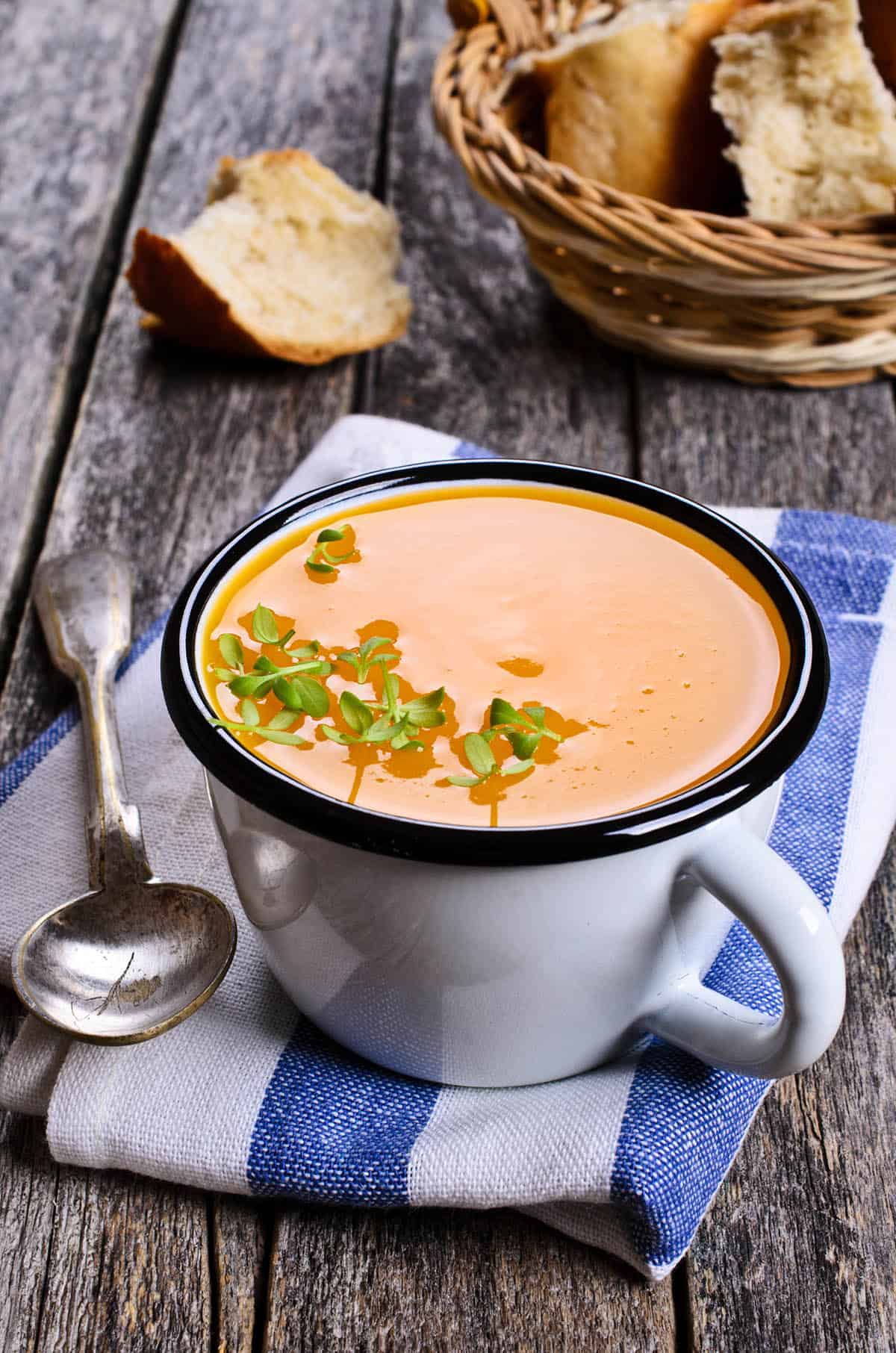 Portrait image overhead of Pumpkin soup in a cup on a wooden background