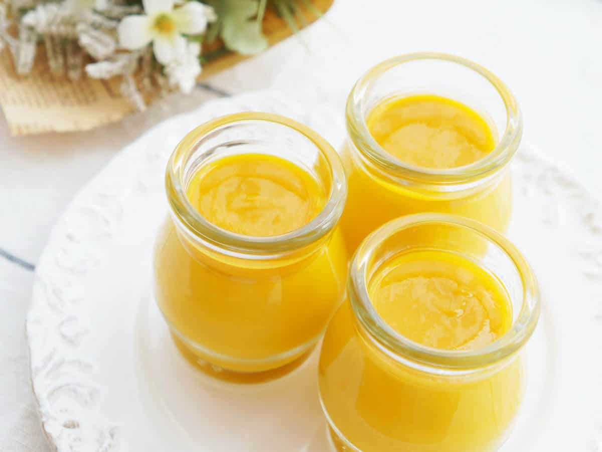 Mango Pudding made in the Thermomix on a white background presented in glass bottles