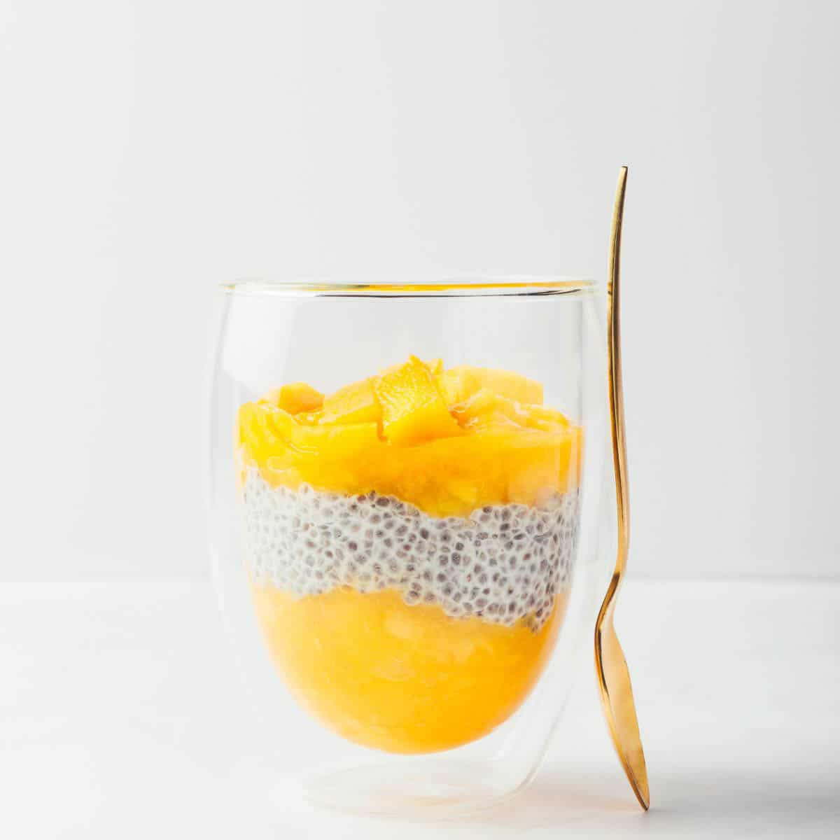 Mango and Chia Seed layered Breakfast Pudding in a clear glass