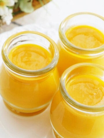 Mango Coconut Pudding made in the Thermomix on a white background presented in glass bottles