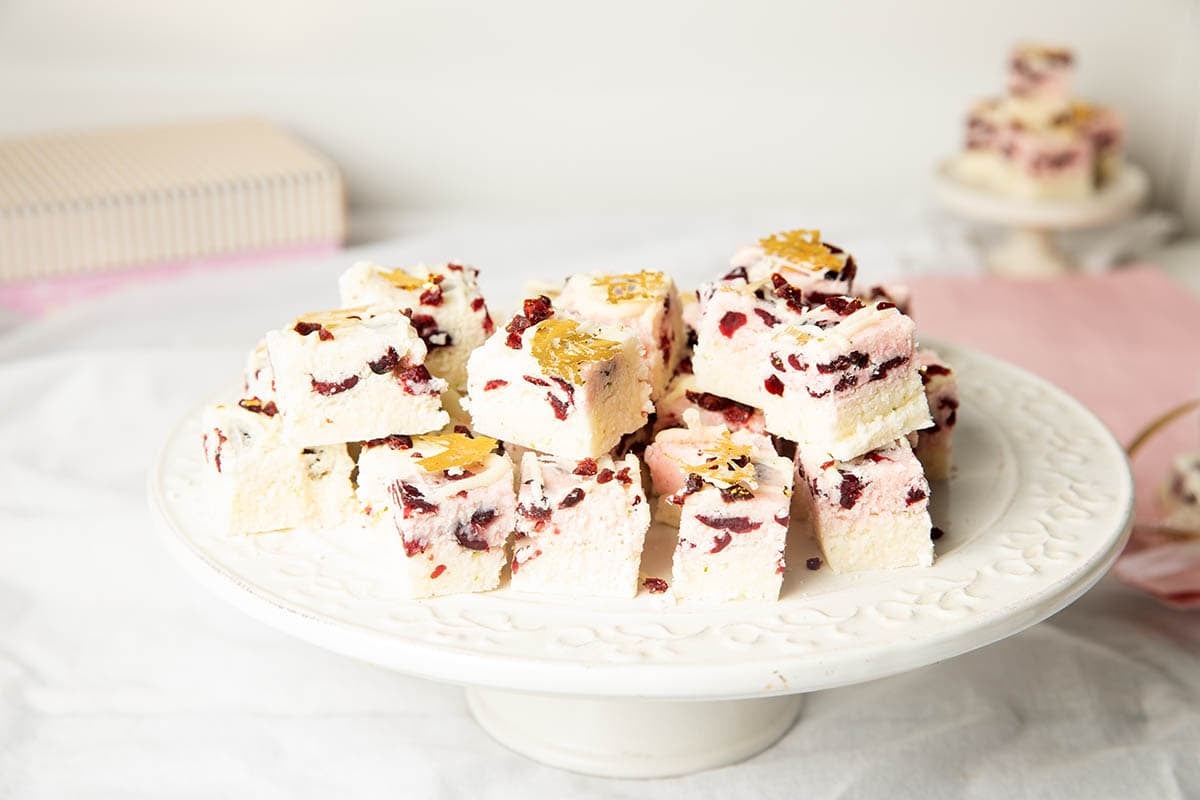 coconut Ice on a white platter with more in the background, pink and white scene