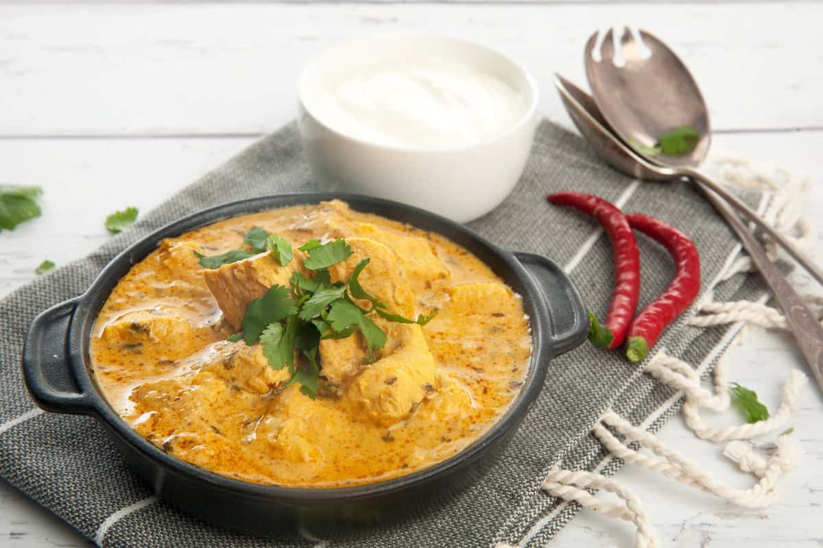 Thermomix Indian Chicken Curry on white background with yoghurt
