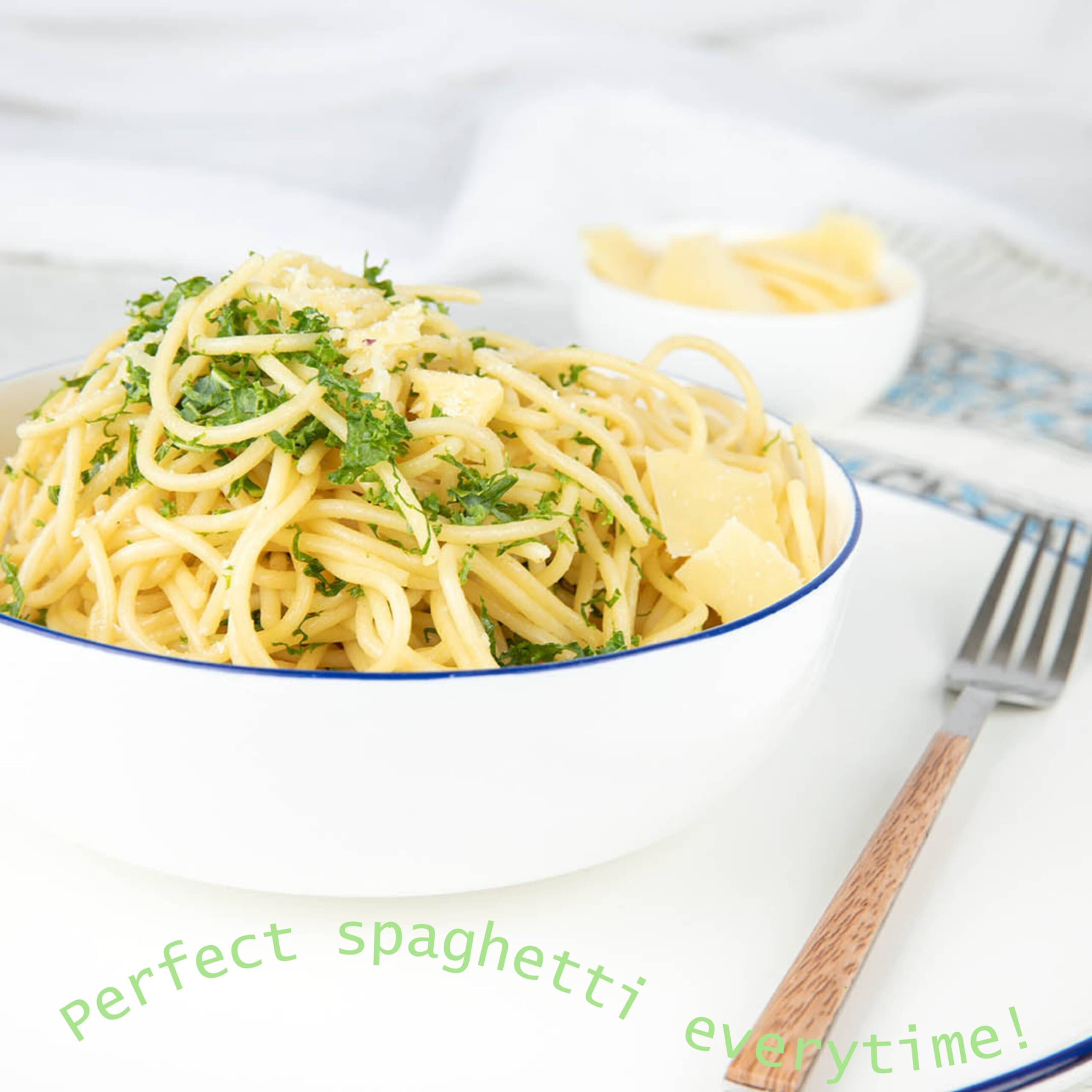 How to boil long pasta and spaghetti in a Thermomix without chopping shown in a white bowl on white background.